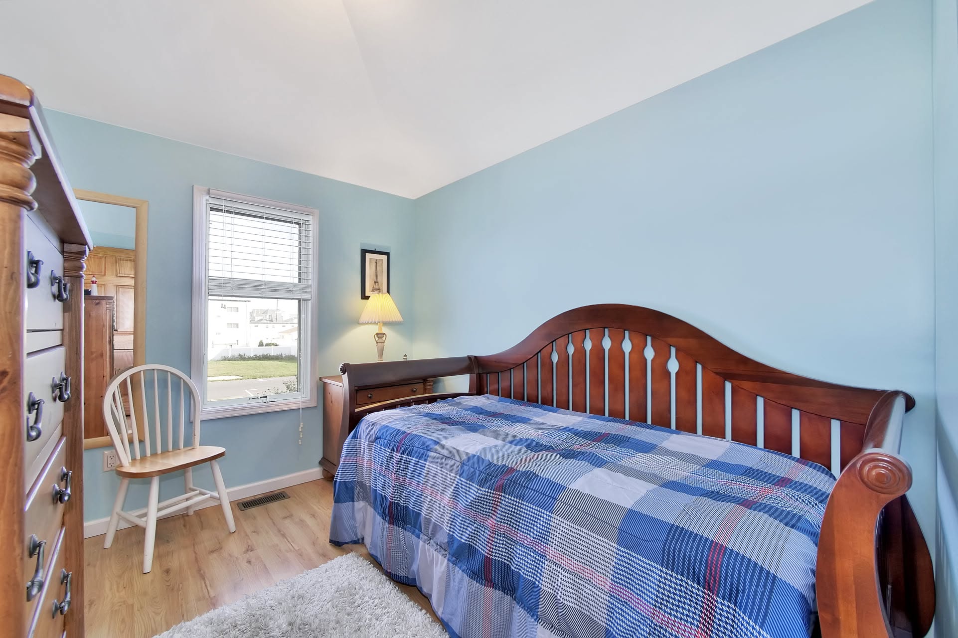 Bedroom with light blue walls and a queen bed
